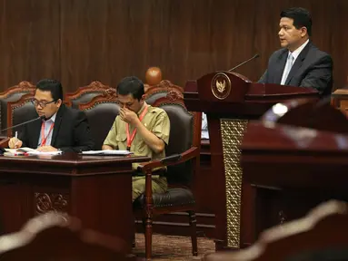 Ketua KPU Husni Kamil Manik menyampaikan keterangan pada sidang peninjauan kembali UU Nomor 1 Tahun 2015 tentang Pilkada di MK, Jakarta, Selasa (8/9). Sidang ini menyatukan tiga permohonan yang menguji peraturan yang sama. (Liputan6.com/Faizal Fanani)