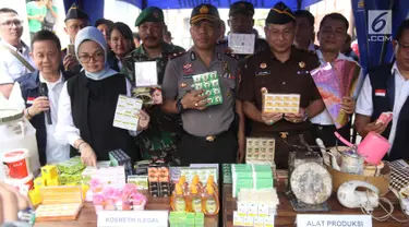 Kepala BPOM RI Penny K Lukito menunjukkan barang bukti kosmetik palsu di kawasan Tambora, Jakarta Barat, Selasa (15/5). Petugas menemukan 21 item produk jadi kosmetik ilegal, bahan baku, dan alat produksi. (Liputan6.com/Arya Manggala)