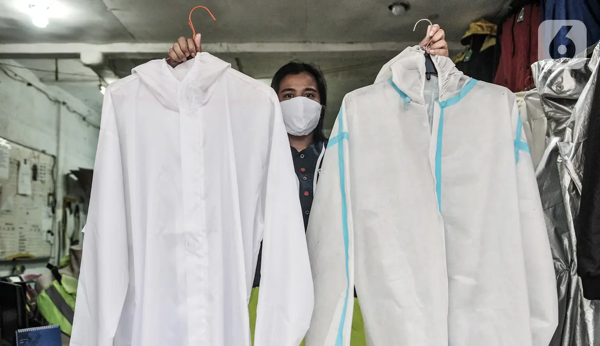Pekerja menunjukkan berbagai jenis baju hazmat yang dijual di salah satu industri konveksi Pusat Industri Kecil (PIK), Jakarta, Rabu (30/12/2020). Selain pesanan langsung, baju hazmat kini laris dijual melalui online shop. (merdeka.com/Iqbal S. Nugroho)