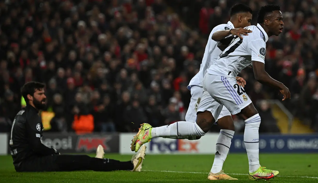 Striker Real Madrid, Vinicius Junior (kanan) melakukan selebrasi setelah mencetak gol ke gawang Liverpool dalam laga leg kedua babak 16 besar Liga Champions 2022/2023 di Anfield Stadium, Liverpool (21/2/2023). Sempat tertinggal dua gol oleh Liverpool saat laga berjalan 14 menit, Real Madrid mampu menyamakan skor 2-2 hingga akhir babak pertama. Di babak kedua Real Madrid menambah tiga gol lagi untuk menyudahi laga dengan kemenangan 5-2. (AFP/Paul Ellis)