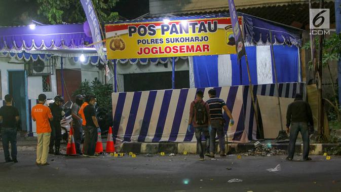 Petugas Inafis dan Polisi melakukan olah TKP di lokasi ledakan bom di Pos Polisi Pantau, Bundaran Kartasura, Sukoharjo Selasa (4/6/2019). Bom bunuh diri terjadi pada Senin pukul 22.20 WIB yang mengakibatkan pelaku aksi teror kritis dan tujuh polisi selamat. (Liputan6.com/Fajar Abrori)