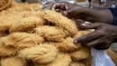 Seorang pria mengatur bihun untuk dijual di pasar pada hari pertama bulan suci Ramadhan di kawasan tua Delhi, India, 3 April 2022. Masjid dan jalan-jalan pasar penuh dengan keramaian malam, tergoda oleh aroma manisan manis untuk berbuka puasa. (Money SHARMA/AFP)