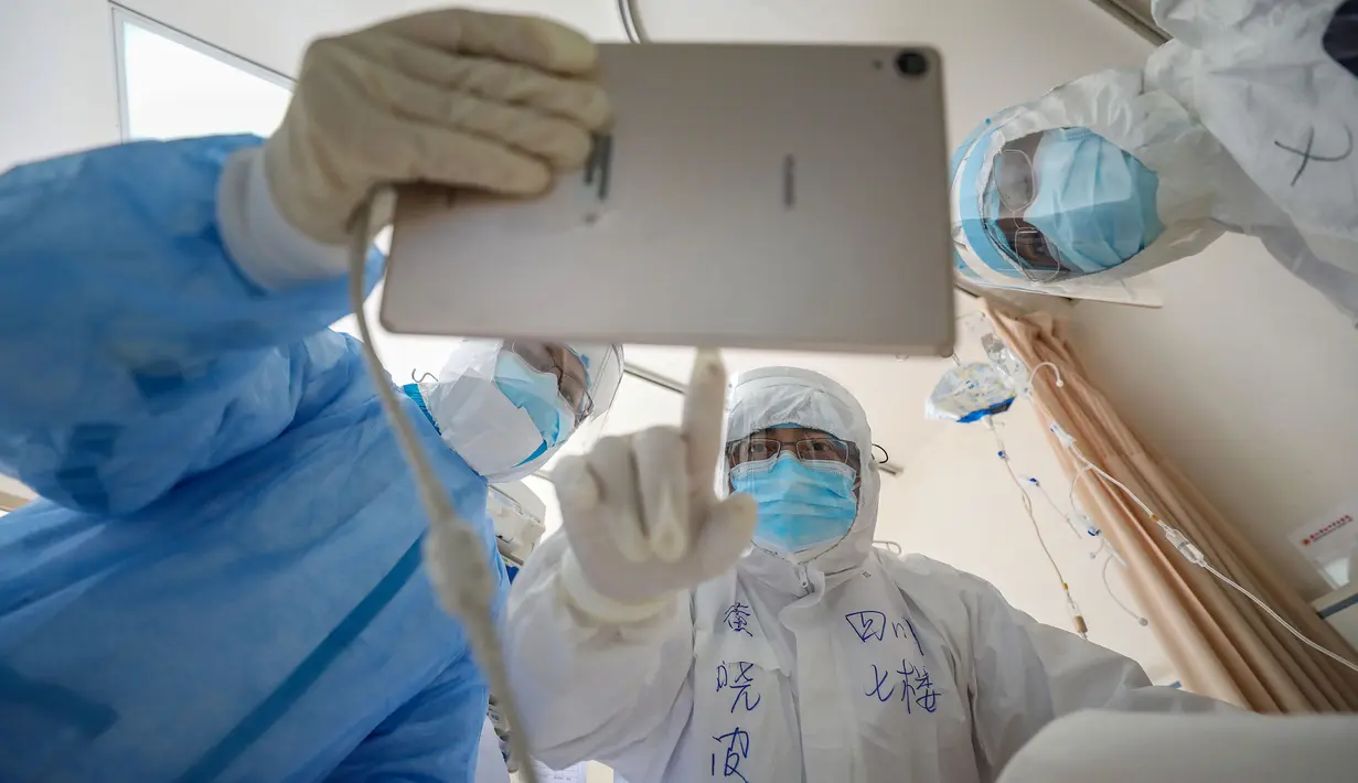 Dokter melihat gambar saat memeriksa pasien yang terinfeksi virus corona (Covid-19) di Rumah Sakit Palang Merah di Wuhan, 16 Februari 2020. Jumlah korban meninggal akibat virus corona (Covid-19) di seluruh dunia hingga Minggu (8/3) pagi sudah mencapai 3.570 orang, terbanyak masih di China. (STR/AFP)