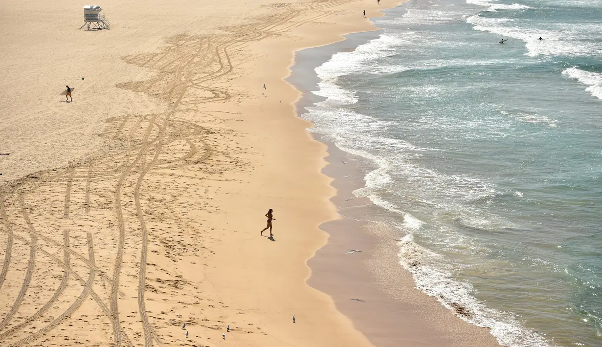 Pantai Bondi yang kosong setelah pemerintah menutup pantai paling populer di Sydney, Minggu (22/3/2020). Otoritas Australia menutup Bondi Beach  lantaran orang-orang mengabaikan larangan pemerintah untuk tidak berkumpul dalam jumlah besar guna menekan penyebaran virus corona. (PETER PARKS/AFP)