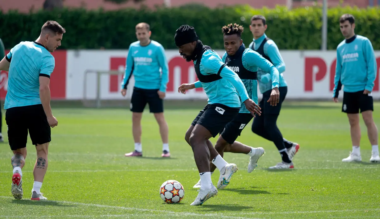 <p>Bek Villarreal, Serge Aurier (tengah kiri) dan gelandang Samuel Chukwueze (tengah kanan) mengikuti sesi latihan di tempat latihan Ciutat Esportiva Vila-Real di Vila-Real, Spanyol, Selasa (26/4/2022). Villarreal akan bertanding melawan wakil Inggris, Liverpool pada leg pertama semifinal Liga Champions. (AFP/Jose Jordan)</p>