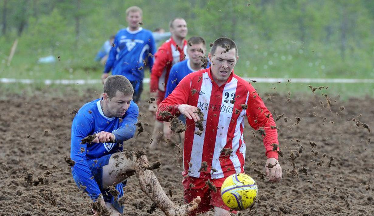 Pemain sepak bola rawa berebut bola dalam turnamen memperebutkan Piala Rusia yang berlangsung di Saint Petersburg, Rusia. Sabtu (27/6). (AFP PHOTO/OLGA MALTSEVA)