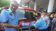 PLT Gubernur DKI Jakarta Soni Sumarsono (kanan) menempelkan stiker integrasi Transjakarta-Koperasi Wahana Kalpika (KWK) saat peresmian di Halaman Balaikota, Jakarta, Senin (3/4). (Liputan6.com/Faizal Fanani)