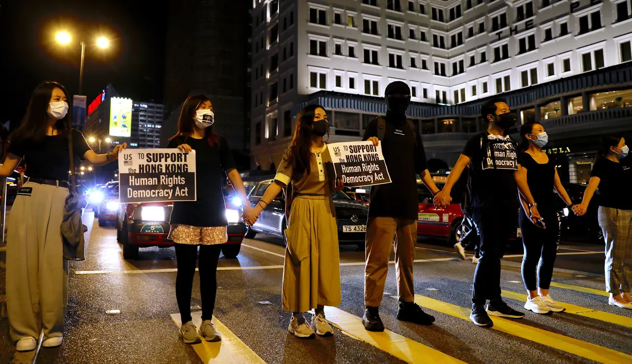Demonstran prodemokrasi membentuk rantai manusia di jalanan Kowloon, Hong Kong, Jumat (23/8/2019). Protes Jumat malam itu tidak berizin, tapi berlangsung damai. (AP Photo/Vincent Yu)