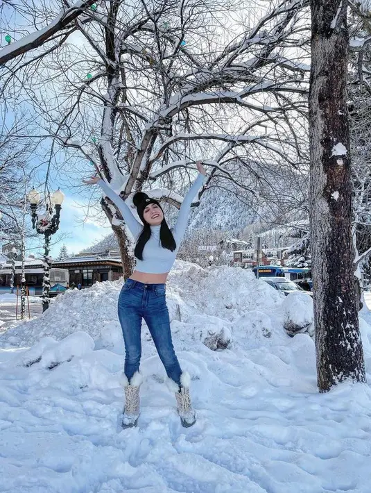 Meski tengah berada di hamparan salju, Shandy Aulia tetap bergaya seksi dengan cropped top, celana jeans dan beanie. (Instagram/shandyaulia).