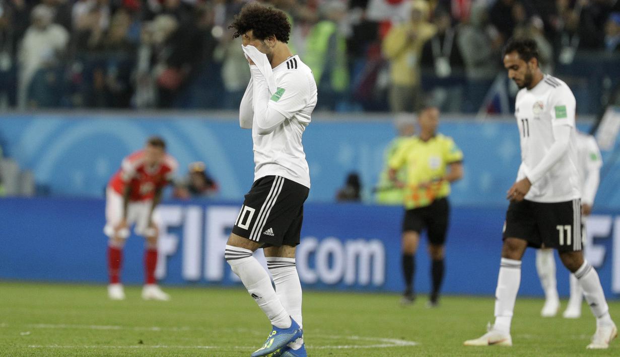 Striker Mesir, Mohamed Salah, menutup wajahnya usai ditaklukkan Rusia pada laga Piala Dunia 2018 di Stadion Krestovsky, Saint-Petersburg, Rabu (20/6/2018). Rusia menang 3-1 atas Mesir. (AP/Gregorio Borgia)