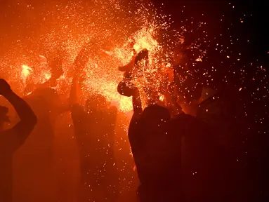 Sejumlah pemuda berpartisipasi dalam upacara perang api, yang secara lokal dikenal sebagai Siat Geni, di sebuah kuil di Tuban dekat Denpasar, Bali (13/10/2019). Ritual Siat Geni diadakan setiap tahun untuk mendorong kaum muda berani dan menolak nasib buruk. (AFP Photo/Sonny Tumbelaka)