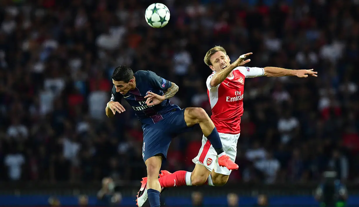 Gelandang PSG, Angel Di Maria, duel udara dengan bek Arsenal, Nacho Monreal. Meski unggul, PSG tetap berupaya melakukan serangan-serangan ke pertahanan The Gunners. (AFP/Franck Fife)