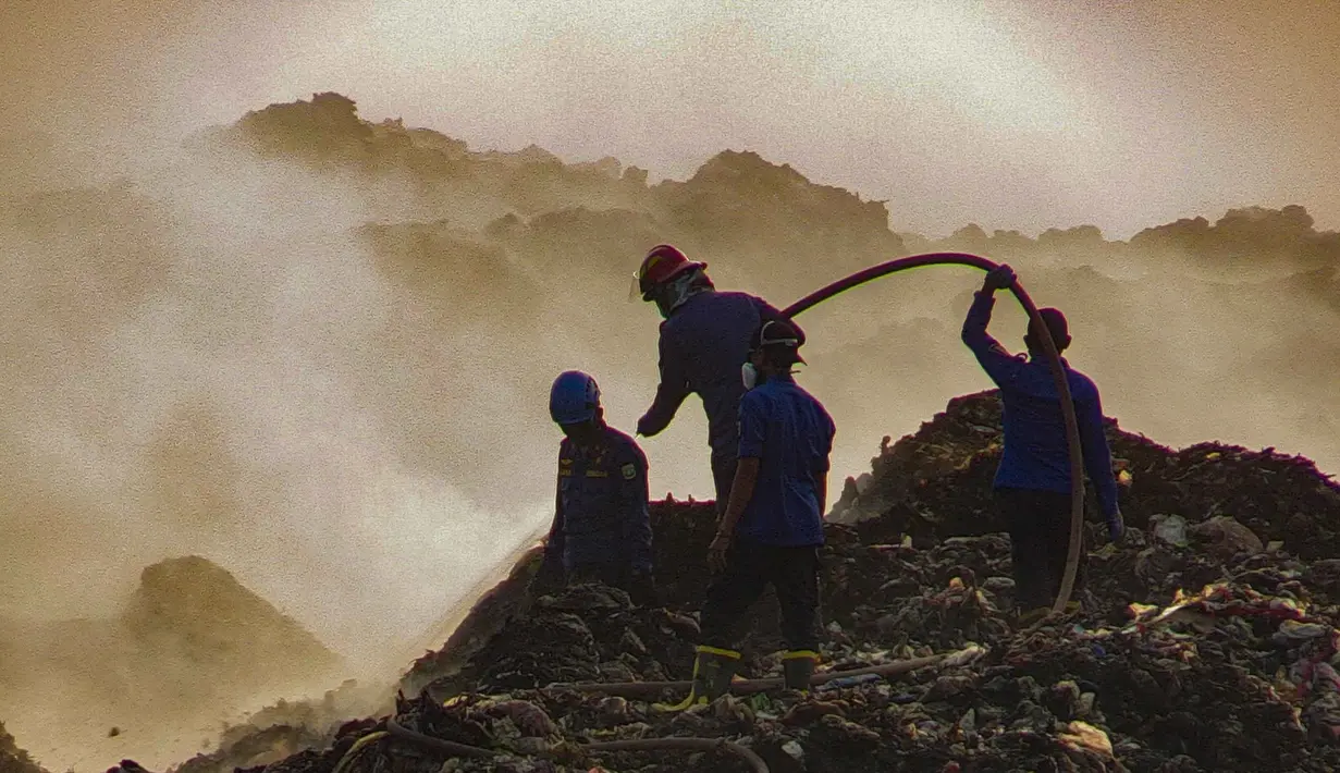 Petugas pemadam kebakaran berusaha memadamkan api di Tempat Pembuangan Akhir (TPA) Jatiwaringin, Kabupaten Tangerang, Banten, Jumat (03/07/2026). (Merdeka.com/ Arie Basuki)