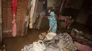 Hingga Sabtu 15 Maret 2025, warga masih kesulitan melakukan pembersihan lokasi tempat tinggal mereka dikarenakan banyak material yang terbawa saat banjir terjadi. (REZAN SOLEH/AFP)