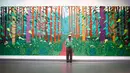 Pelukis asal inggris David Hockney berpose di depan lukisan besarnya di Perpustakaan Pompidou Center, Paris, Perancis, Selasa (26/9). Lukisan ini mencakup 32 panel dengan tinggi 3 meter dan lebar hampir 10 meter. (Foto AP/Francois Mori)
