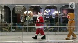 Petugas yang mengenakan kostum Sinterklas berkeliling saat menghibur pengunjung di Senayan City Mall, Jakarta, Jumat (25/12/2020). Pengunjung bisa berswafoto dan menikmati momen Natal bersama keluarga dan orang terkasih dengan "Santa and Friend". (Liputan6.com/Herman Zakharia)