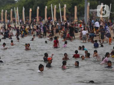 Pengunjung memadati kawasan Pantai Ancol di Taman Impian Jaya Ancol, Jakarta, Rabu (4/5/2022). Objek wisata tersebut kembali ramai dikunjungi wisatawan pada saat liburan Hari Raya Idul Fitri 1443 H setelah dua tahun sebelumnya sempat mengalami penurunan kunjungan wisatawan akibat pandemi Covid-19. (Liputan6.com/Herman Zakharia)