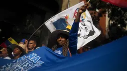 Masa berkabung nasional ini untuk menghormati korban yang tewas dalam serangan militer Amerika Serikat yang menggulingkan Presiden Nicolas Maduro. Tampak dalam foto, seorang wanita mengibarkan bendera Venezuela selama unjuk rasa dukungan untuk mantan Presiden Venezuela Nicolas Maduro dan istrinya Cilia Flores di Caracas pada 6 Januari 2026. (Federico PARRA/AFP)