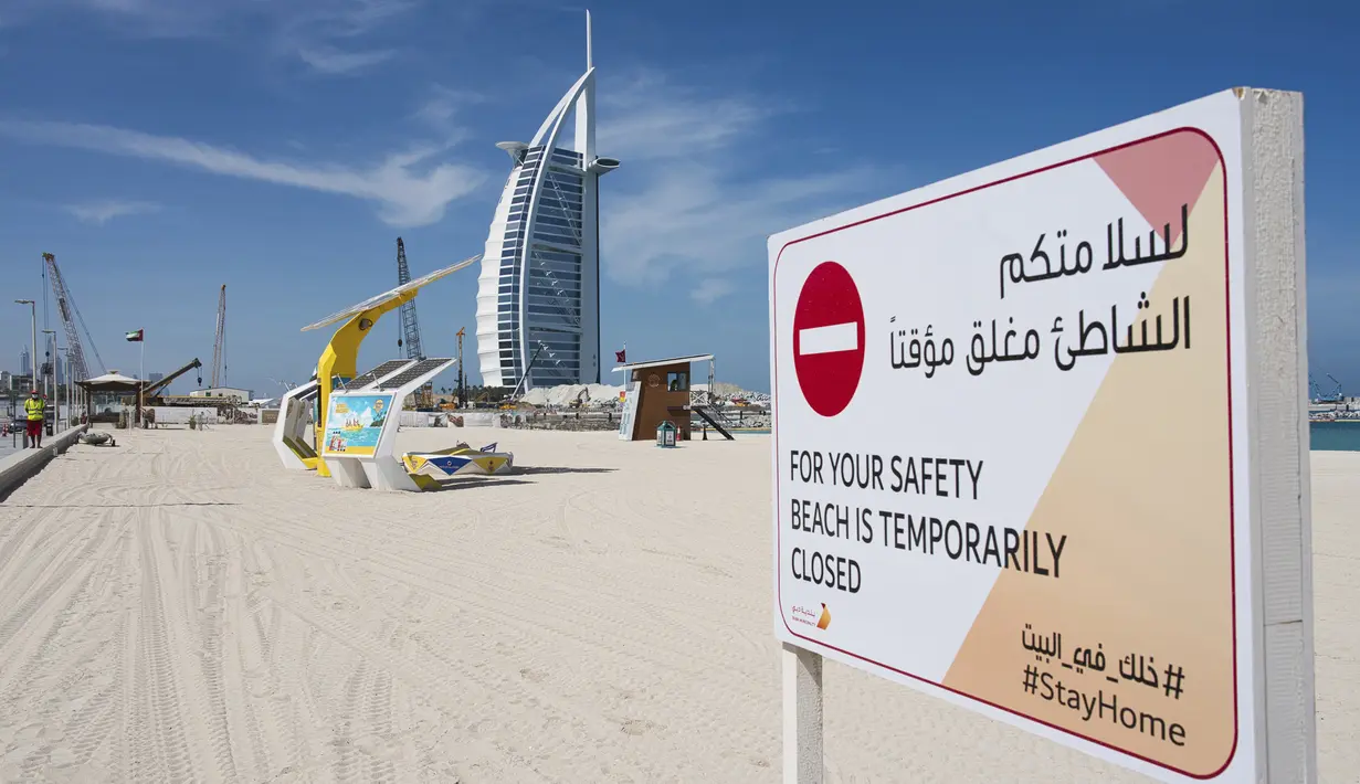 Papan pemberitahuan penutupan pantai terpasang di dekat Burj Al-Arab, Dubai, Uni Emirat Arab, Senin (6/4/2020). Pemerintah Dubai hanya mengizinkan satu orang anggota keluarga bepergian untuk mencari makanan dan obat-obatan. (AP Photo/Jon Gambrell) (AP Photo/Jon Gambrell)