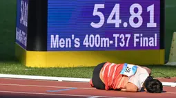 Reaksi atlet Indonesia, Saptoyogo Purnomo setelah memenangkan cabang olahraga Para Athletics Asian Para Games 2023 nomor Men's 400m-T37 yang berlangsung di Huanglong Sport Centre Stadium, Provinsi Zhejiang, China, Senin (23/10/2023). Ia mencatatkan waktu 54.80 detik. (AFP/Hector Retamal)