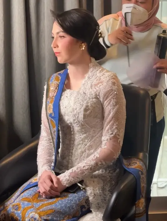 Melengkapi tampilannya dengan anting-anting bunga warna emas. Serta tusuk konde emas di atas rambut sanggulnya. Wajahnya dipoles blush on pink senada dengan lipstiknya.  [@arumibachsin_94]