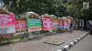 Pekerja meletakkan karangan bunga bertuliskan ucapan selamat untuk Joko Widodo dan Ma'ruf Amin di depan pagar gedung Sekretariat Negara, Jakarta, Senin (22/4). Karangan bunga dari pendukung Jokowi-Ma'ruf tersebut ditujukan atas kemenangan pasangan itu pada Pilpres 2019. (Liputan6.com/Faizal Fanani)