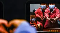Staf medis dari Provinsi Hunan memberi isyarat ucapan selamat tinggal di dalam kereta di Stasiun Kereta Api Wuhan di Provinsi Hubei, China (17/3/2020). Beberapa tim bantuan medis  mulai meninggalkan Hubei ketika epidemi COVID-19 yang terkena dampak paling parah itu terus menurun. (Xinhua/Shen Bohan)
