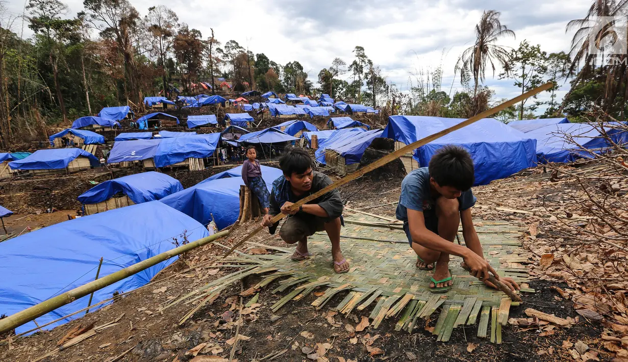 Dua orang Suku Baduy Luar sedang membuat dinding dari bambu di Kampung Cisaban II, Desa Kanekes, Banten, Kamis (01/6). Warga Baduy Luar mulai membangun kembali rumah mereka yang terbakar beberapa waktu lalu. (Liputan6.com/Fery Pradolo)