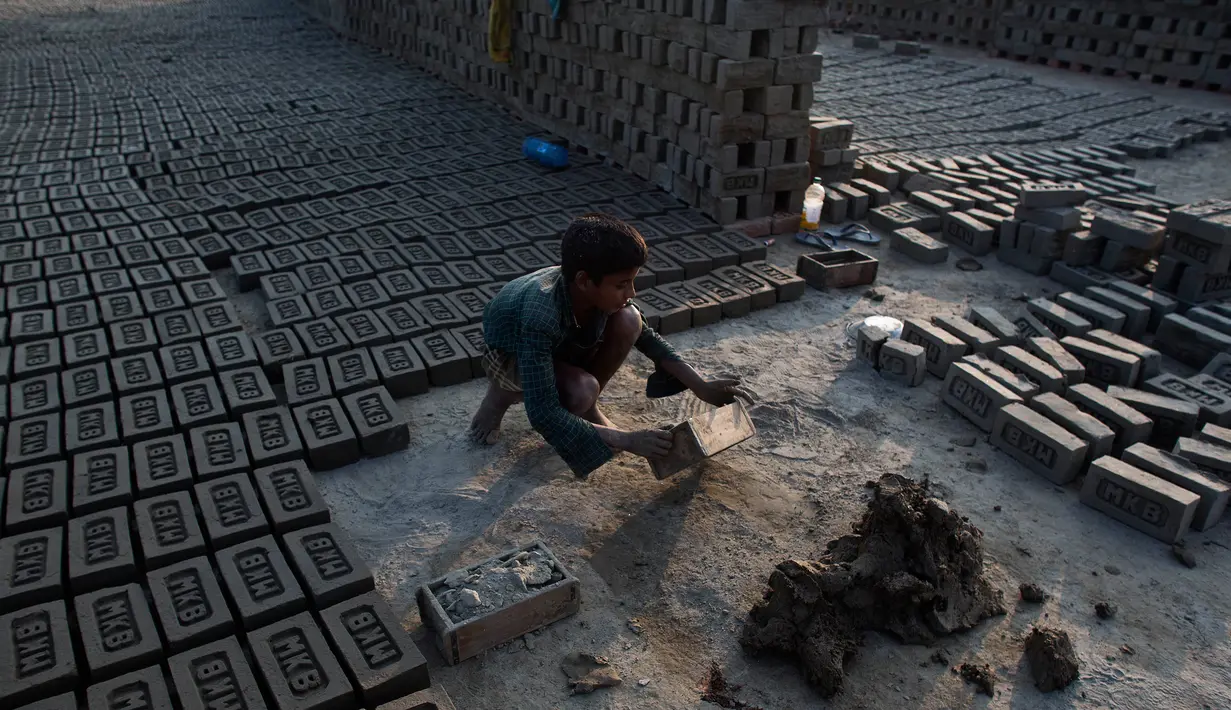 Seorang anak kecil India bekerja di sebuah tungku batu bata di pinggiran Gauhati, India (22/11). Sebagian besar buruh di sini mendapatkan Rupee 120 (kurang dari 2 Dolar) per hari. (AP Photo/Anupam Nath)