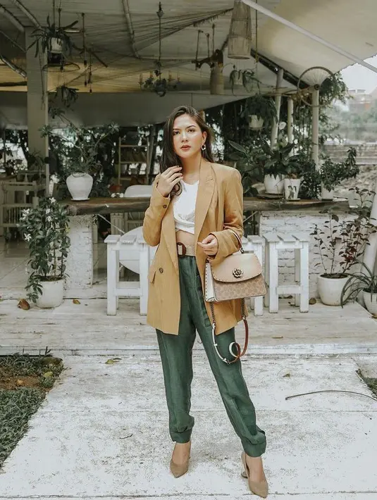 Jessica Mila mengenakan cropped top warna putih yang dipadukan blazer warna khaki dan dipadukan dengan celana bahan warna army. (Instagram/jscmila).