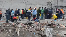 Petugas penyelamat mencari korban dan orang yang selamat melalui reruntuhan bangunan di Kahramanmaras, Turki, sehari setelah gempa bumi berkekuatan 7,8 skala Richter menghantam bagian tenggara negara itu, Selasa (7/2/2023). Tim penyelamat di Turki dan Suriah menerjang cuaca dingin disertai gempa susulan serta bangunan yang runtuh, ketika mereka menggali korban yang tertimbun oleh gempa bumi yang menewaskan lebih dari 5.000 orang. (ILYAS AKENGIN/AFP)