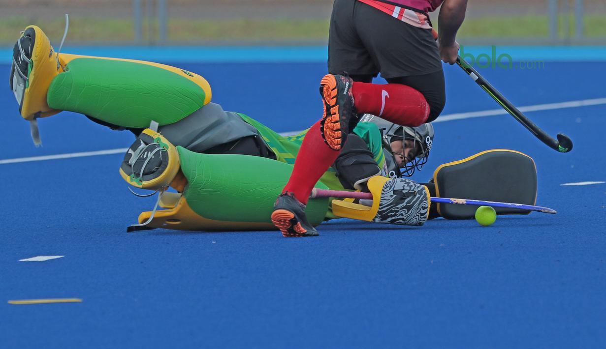 Penjaga gawang Timnas Hoki Putri Indonesia berusaha menghalau bola dari tembakan rekannya saat latihan di Lapangan Hoki, Senayan, Jakarta, Selasa (2/4/2018). Tim Hoki terus melakukan adaptasi lapangan jelang Asian Games 2018. (Bola.com/Nick Hanoatubun)
