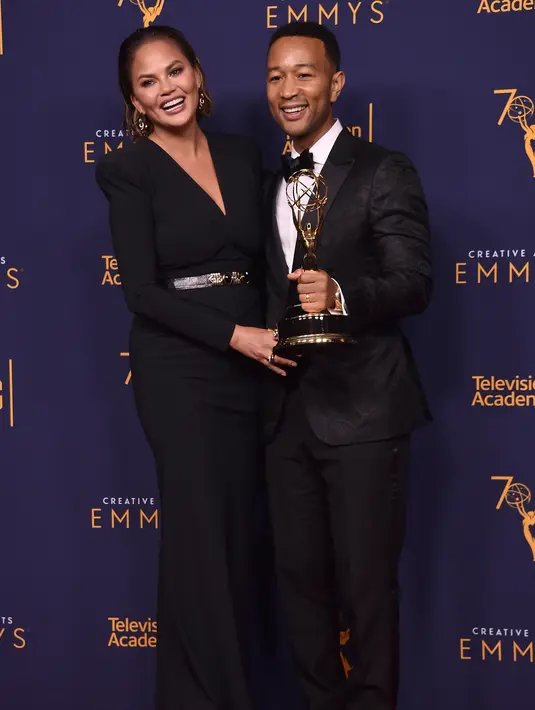 Chrissy Teigen dan John Legend berpose selama Creative Arts Emmy di Los Angeles, California, (9/9). John Legend memenangkan penghargaan untuk Outstanding Variety Special (Live) for Jesus Christ Superstar Live in Concert. (AFP Photo/Alberto E. Rodriguez)