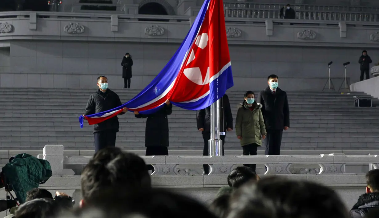 Upacara pengibaran bendera nasional pada pertunjukan Tahun Baru di Kim Il-sung Square, Pyongyang, Korea Utara, Sabtu (1/1/2022). Ratusan orang di Pyongyang berkumpul dengan mengenakan masker untuk menyaksikan pertunjukan kembang api menyambut Tahun Baru 2022. (AP Photo/Cha Song Ho)
