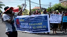 Ikatan Mahasiswa Pelajar dan Masyarakat Papua (IMMAPA) membawa spanduk saat berunjuk rasa di Lapangan Niti Mandala, Denpasar, Bali, Kamis (22/8/2019). Protes atas insiden yang terjadi di Asrama Papua di Surabaya ini diikuti oleh puluhan peserta. (SONNY TUMBELAKA/AFP)