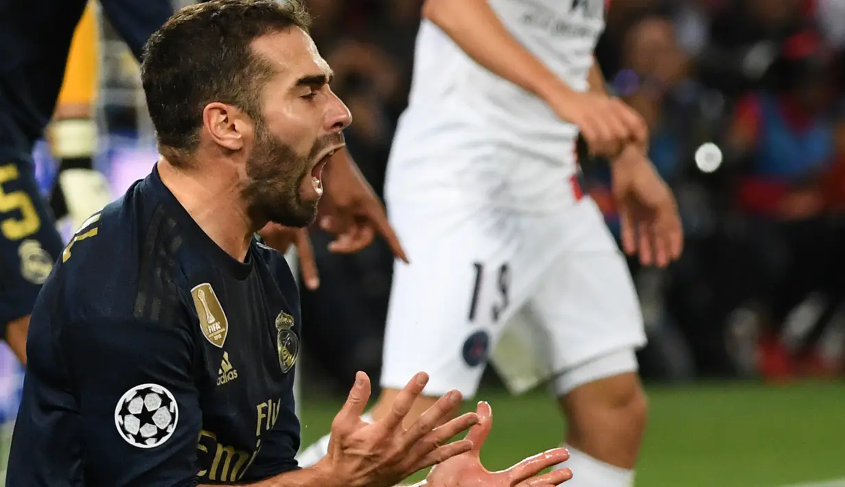 Reaksi  bek Real Madrid, Dani Carvajal pada laga Grup A Liga Champions melawan Paris Saint-Germain (PSG) di Parc des Princes, Rabu (18/9/2019). Real Madrid kalah telak dengan skor 0-3. (MARTIN BUREAU / AFP)