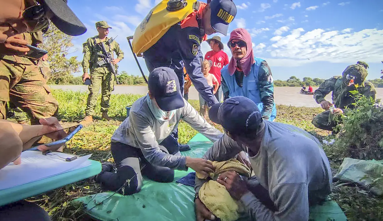 Gambar selebaran yang dirilis oleh Angkatan Laut Kolombia menunjukkan petugas memeriksa kondisi salah satu dari dua lumba-lumba merah muda (pink), spesies terancam punah, yang terperangkap di perairan dangkal di Juriepe, Departemen Vichada, Senin (20/2/2023). Warga memberi tahu pihak berwenang tentang lumba-lumba yang terperangkap di Sungai Meta Kolombia timur, anak sungai Orinoco di dekat perbatasan Venezuela, pekan lalu. (COLOMBIA'S NAVY / AFP)