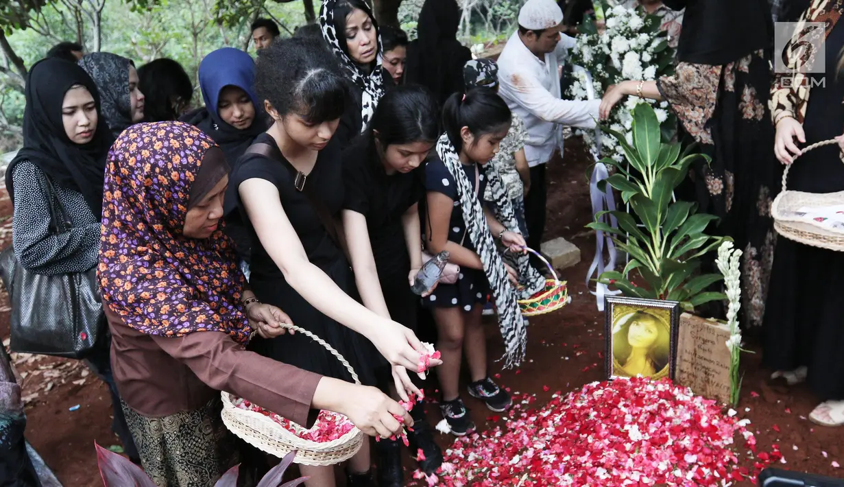 Penaburan bunga di atas makam Yana Zein di TPU Gandul, Cinere, Depok, Jumat (2/6). Yana Zein meninggal pada kamis (1/6/2017), karena kanker payudara stadium VI yang dideritanya. (Liputan6.com/Herman Zakharia)