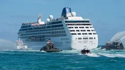 Kapal patroli menyemprotkan meriam air saat keberangkatan kapal pesiar milik Carnival, Adonia menuju Kuba dari Miami, Florida, Minggu (1/5). Perjalanan The Adonia ini merupakan yang pertama kali dilakukan setelah 50 tahun terakhir (Gaston De CARDENAS/AFP)