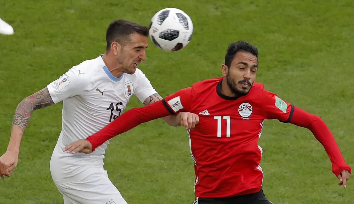 Gelandang Uruguay, Matias Vecino, duel udara dengan pemain Mesir, Kahraba, pada laga Piala Dunia di Stadion Ekaterinburg, Jumat (15/6/2018). Uruguay menang 1-0 atas Mesir. (AP/Vadim Ghirda)