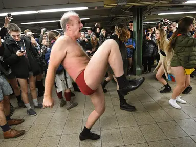 Peserta berjoged saat berpartisipasi dalam "No Pants Subway Ride" di atas platform kereta bawah tanah New York City, USA (10/1//2016). Acara ini dimulai pada tahun 2002 dengan peserta hanya tujuh orang. (AFP PHOTO/TIMOTHY A. Clary)