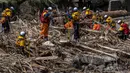 Petugas penyelamat mencari orang-orang yang hilang dalam puing-puing yang hanyut akibat banjir di sungai Tsukada setelah hujan lebat di kota Wajima, prefektur Ishikawa pada Senin 23 September 2024. (Yuichi YAMAZAKI/AFP)