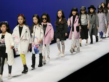 Sejumlah anak dengan lucunya berjalan diatas catwalk mengenakan busana kreasi dari Ting Zu pada China Fashion Week,  Cina , (27/3). (REUTERS / Kim Kyung - Hoon)