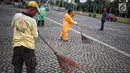 Petugas kebersihan membersihkan sisa sampah usai perayaan Tahun Baru 2019 di Monas, Jakarta, Selasa (1/1). Total sampah di DKI Jakarta saat perayaan Tahun Baru 2019 berkurang dari tahun lalu. (Liputan6.com/Faizal Fanani)