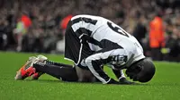 Mantan striker Newcastle United, Demba Ba, melakukan sujud syukur usai mencetak gol ke gawang Arsenal. (GLYN KIRK / AFP)