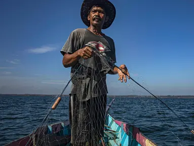 Erwin, seorang nelayan, menggunakan jaring untuk menangkap ikan di perairan Tanah Kuning, dekat lokasi pengembangan Kalimantan Industrial Park Indonesia, di Kalimantan Utara, Indonesia pada hari Kamis, 24 Agustus 2023. (AP Photo/Yusuf Wahil)