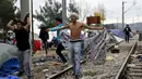 Imigran memberikan perlawanan saat Polisi Makedonia melarang para imigran mendirikan tenda di sekitar rel kereta api di Desa Idomeni, Yunani (28/11/2015). (REUTERS/Yannis Behrakis)