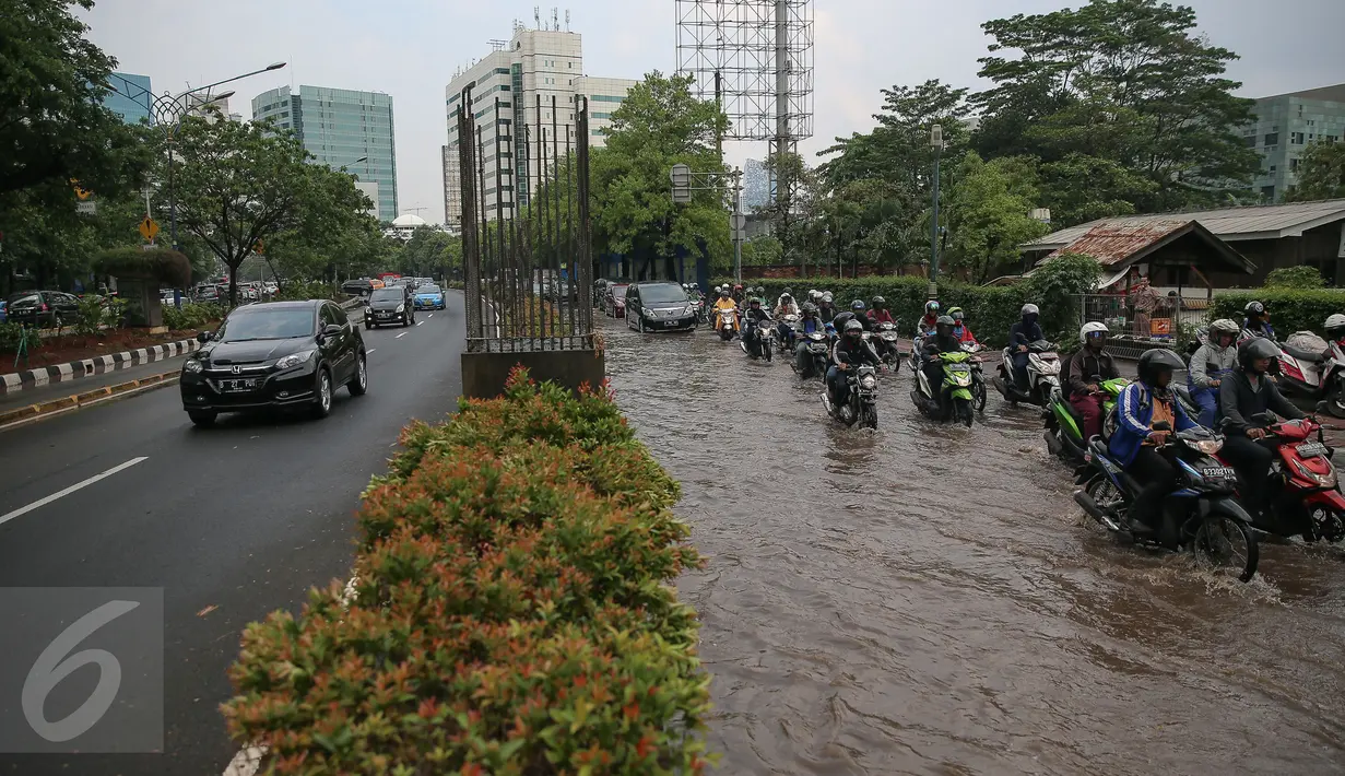 Sejumlah mobil melintas di jalur cepat di Kawasan Kuningan, Jakarta, Selasa (24/11). Jalur lambat di Jalan HR Rasuna Said, Kuningan, tampak dihindari oleh pengendara karena terdapat genagan air setinggi 20 cm. (Liputan6.com/Faizal Fanani)