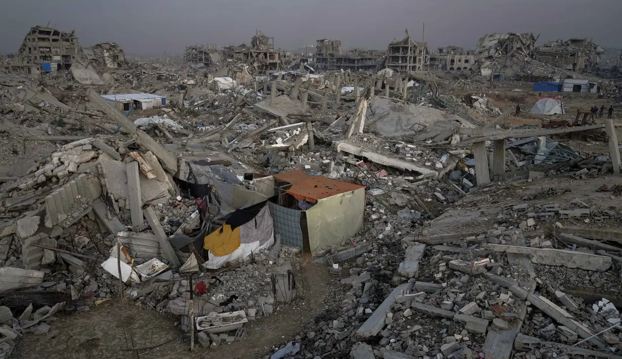 Sebuah tenda milik keluarga Magdi Arafat berdiri di antara reruntuhan rumah-rumah di lingkungan Al-Zaytoun, Kota Gaza, Jumat 27 November 2025. Gencatan senjata fase pertama resmi berlaku sejak 10 Oktober 2025, banyak warga Palestina di Jalur Gaza meninggalkan tempat pengungsian untuk kembali ke rumah mereka. (AP Photo/Jehad Alshrafi)