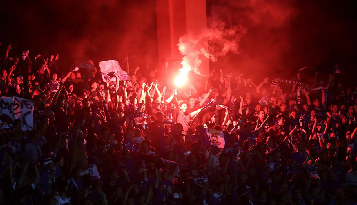 Suporter Persib Bandung menyalakan suar saat pertandingan antara Persib melawan Pusamania Borneo FC dalam laga leg kedua perempatfinal Piala Presiden 2015 di Stadion Si Jalak Harupat, Bandung, Sabtu (26/9/2015). (Bola.com/Arief Bagus)